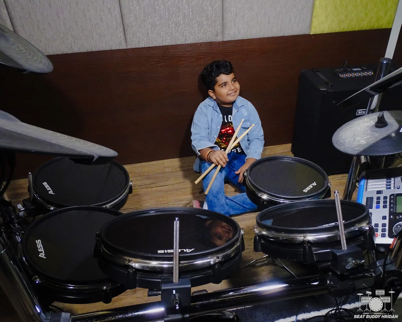 An early photo of young Hridan exploring an electronic drum kit