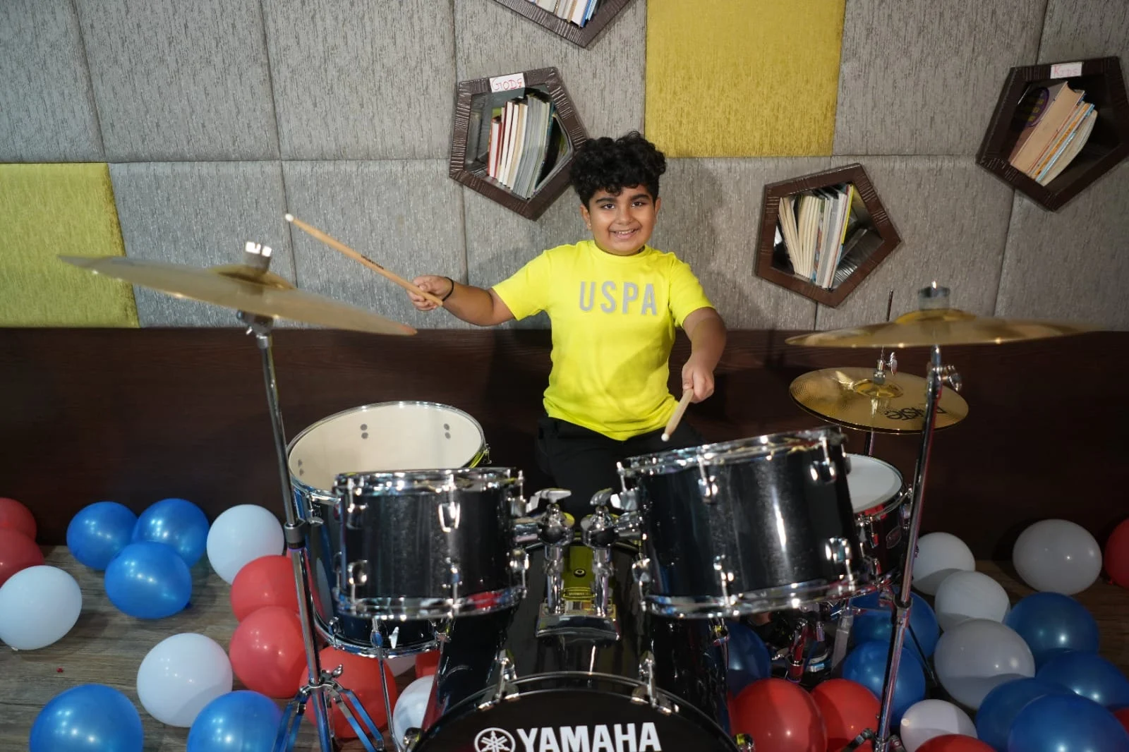 Hridan practising on an acoustic drum kit in the studio